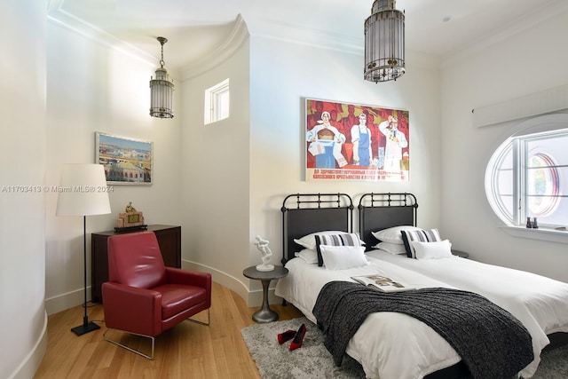 bedroom featuring ornamental molding and light wood-type flooring