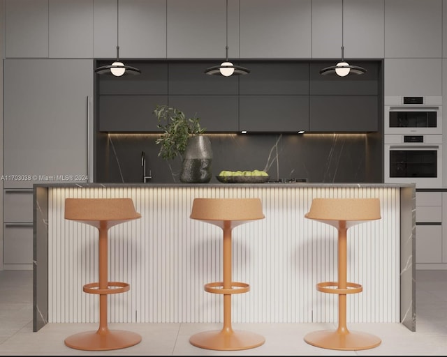 bar with sink, double oven, pendant lighting, gray cabinets, and light tile patterned flooring