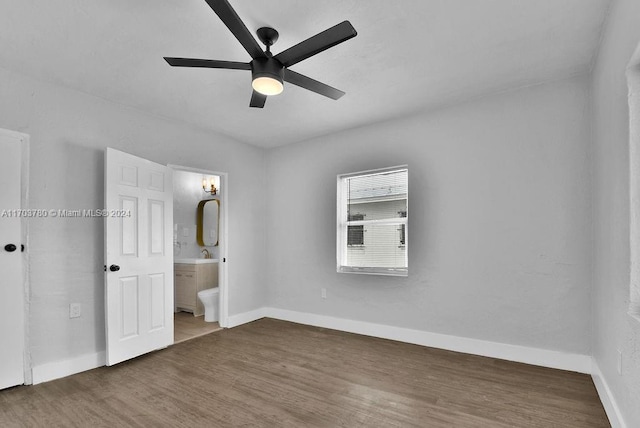 unfurnished bedroom featuring dark hardwood / wood-style floors, ensuite bath, ceiling fan, and sink