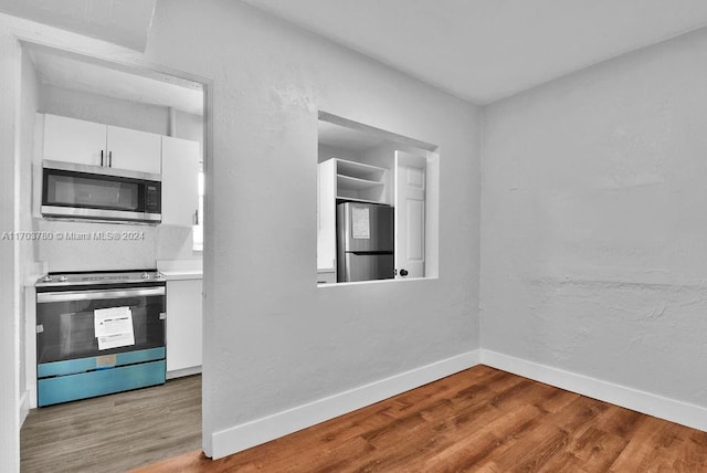 kitchen featuring hardwood / wood-style floors, white cabinets, and stainless steel appliances