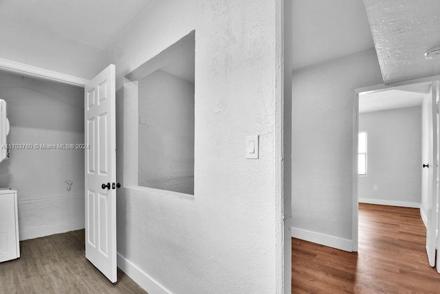 hallway with washer / dryer and hardwood / wood-style flooring