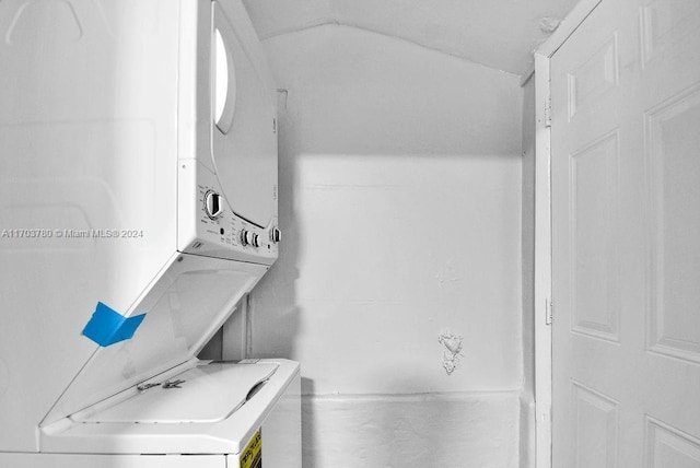 bathroom with stacked washer and dryer and vaulted ceiling