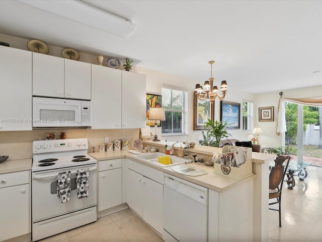 kitchen featuring white cabinetry, sink, hanging light fixtures, a notable chandelier, and white appliances