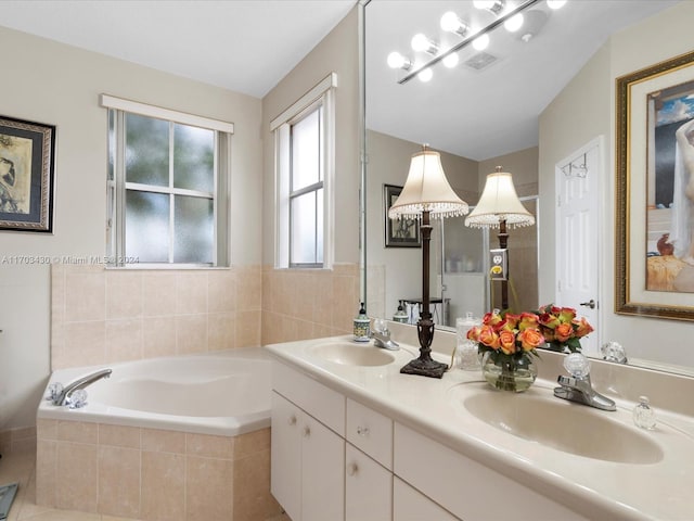 bathroom featuring vanity, tile patterned floors, and tiled tub