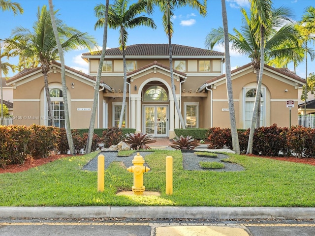 mediterranean / spanish home with french doors and a front lawn