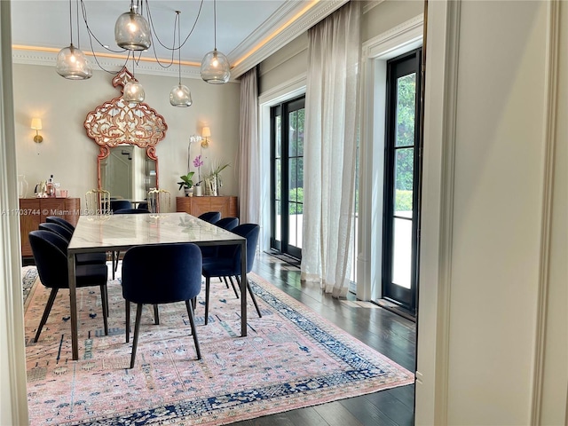 dining area with hardwood / wood-style flooring and crown molding