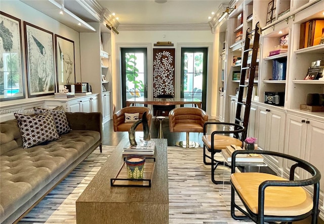 sitting room featuring crown molding, built in features, and light hardwood / wood-style floors