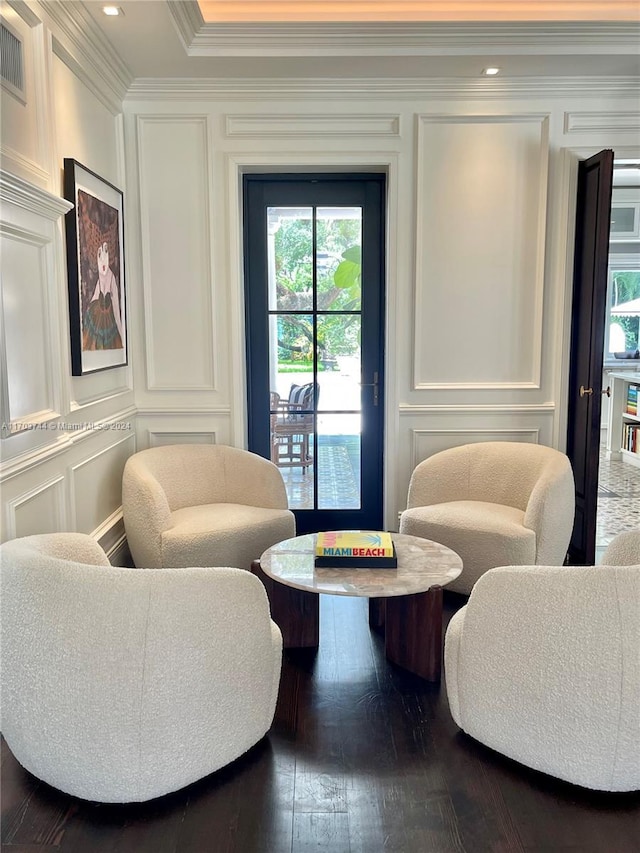 living area featuring wood-type flooring and ornamental molding