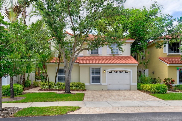 view of front of house featuring a tiled roof, decorative driveway, and stucco siding