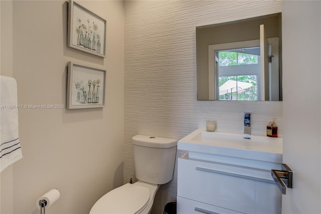 bathroom featuring tile walls, backsplash, vanity, and toilet