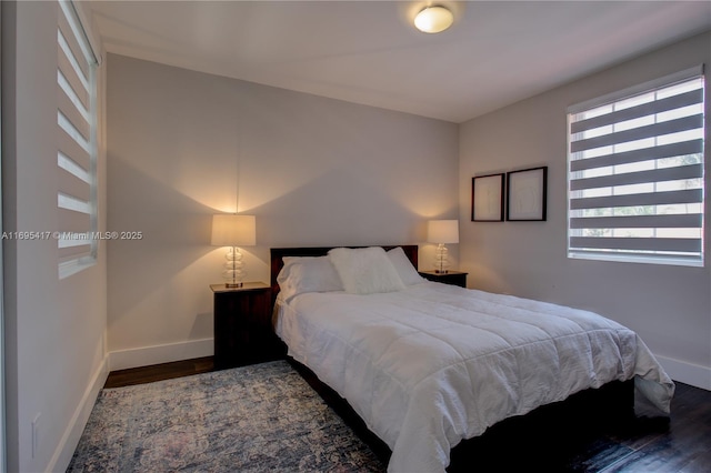 bedroom with baseboards and wood finished floors