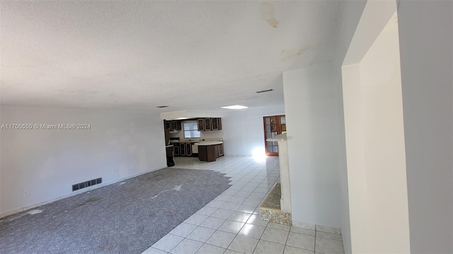 hallway with light tile patterned flooring and a textured ceiling