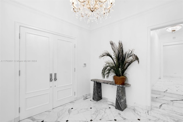 entrance foyer with ornamental molding and a notable chandelier