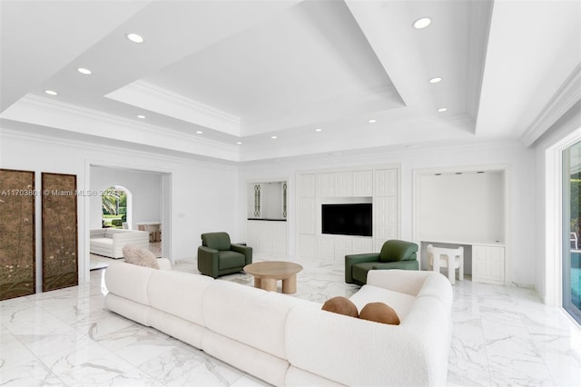 living room with a tray ceiling and ornamental molding