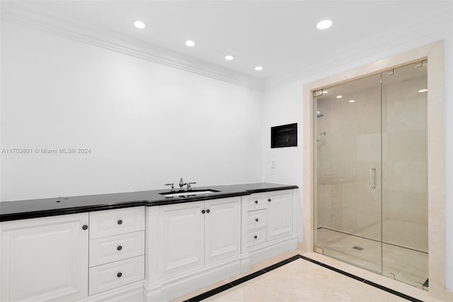 bathroom with tile patterned flooring, vanity, a shower with door, and ornamental molding