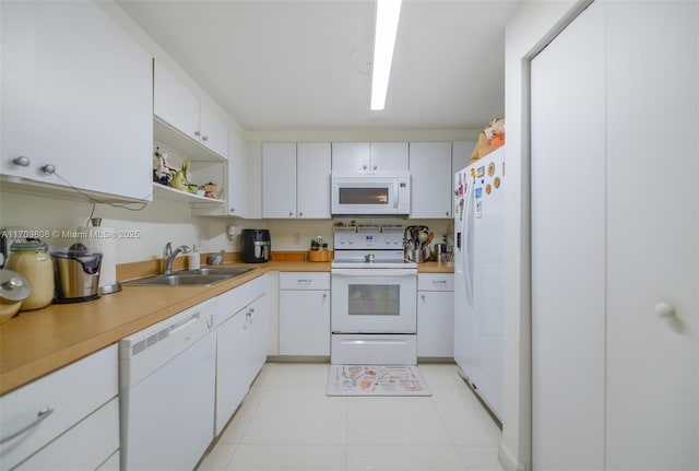 kitchen with sink, light tile patterned floors, white cabinets, and white appliances