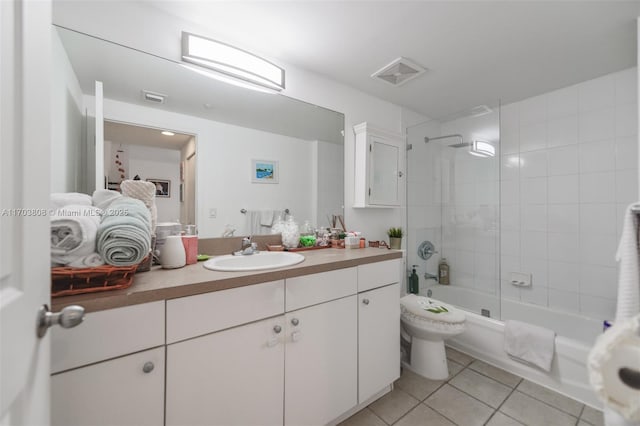 full bathroom featuring tile patterned floors, toilet, tiled shower / bath combo, and vanity