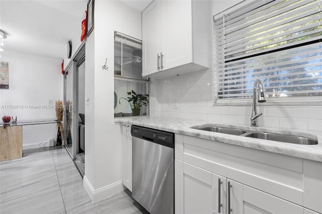 kitchen featuring decorative backsplash, white cabinetry, stainless steel dishwasher, and sink