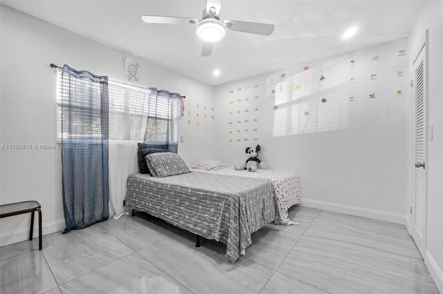 bedroom with a ceiling fan and baseboards