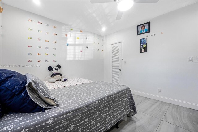 bedroom with lofted ceiling, a closet, a ceiling fan, and baseboards