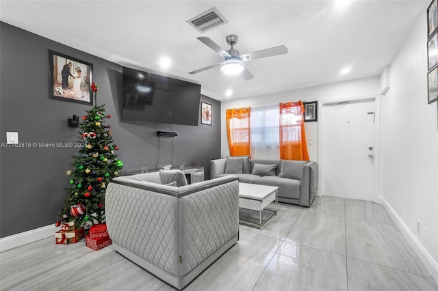 living room featuring ceiling fan, visible vents, and baseboards