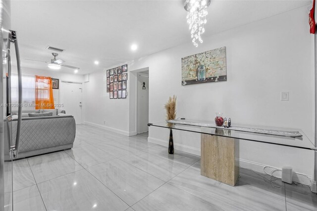 interior space featuring ceiling fan, visible vents, and baseboards