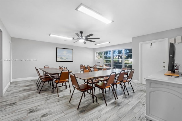 dining space with light wood-style flooring, baseboards, and ceiling fan