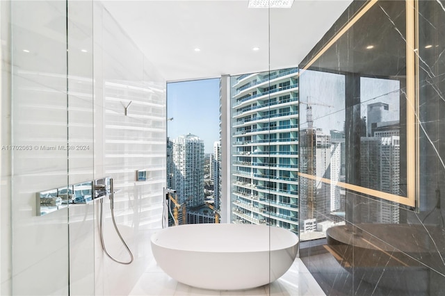 bathroom with tile patterned floors, a wall of windows, and a tub to relax in