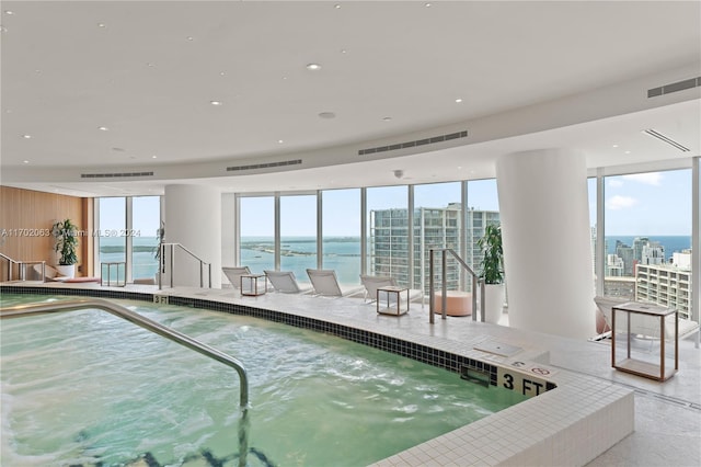 view of swimming pool with a water view and a hot tub