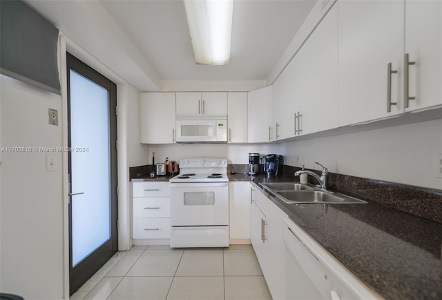 kitchen with white cabinetry, sink, dark stone countertops, white appliances, and light tile patterned flooring