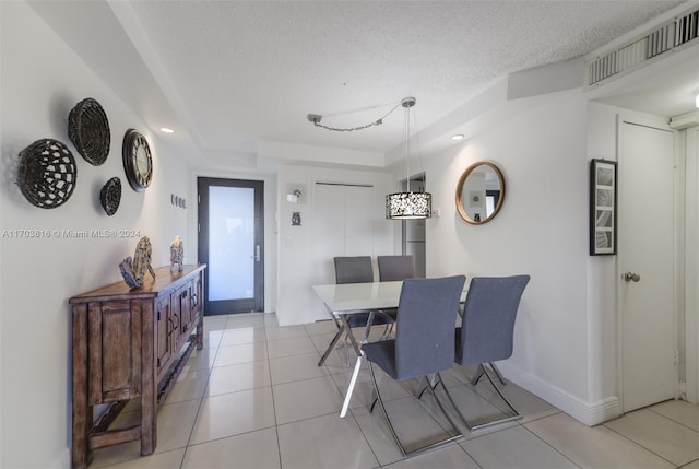 tiled dining area with a textured ceiling