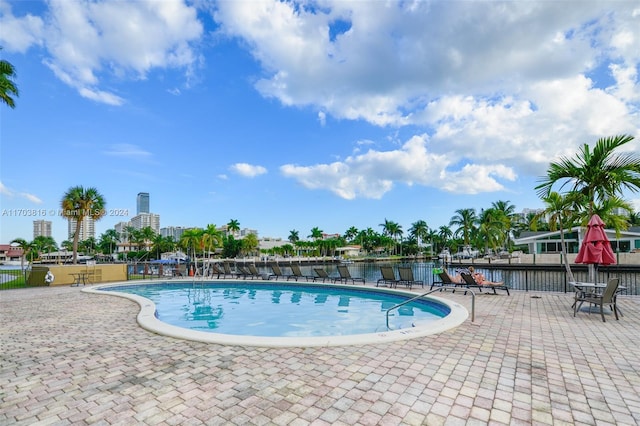 view of pool with a patio area and a water view