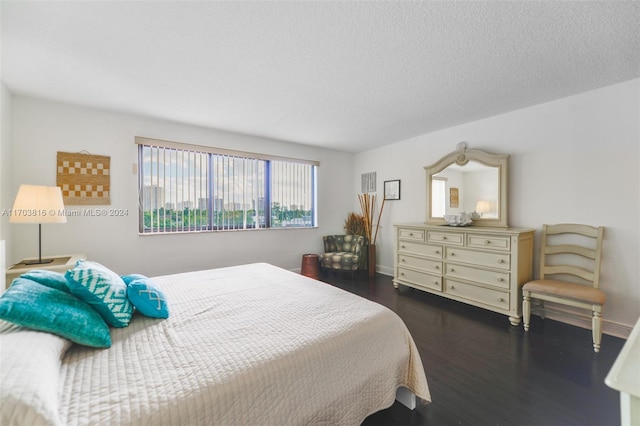 bedroom featuring a textured ceiling and dark hardwood / wood-style flooring