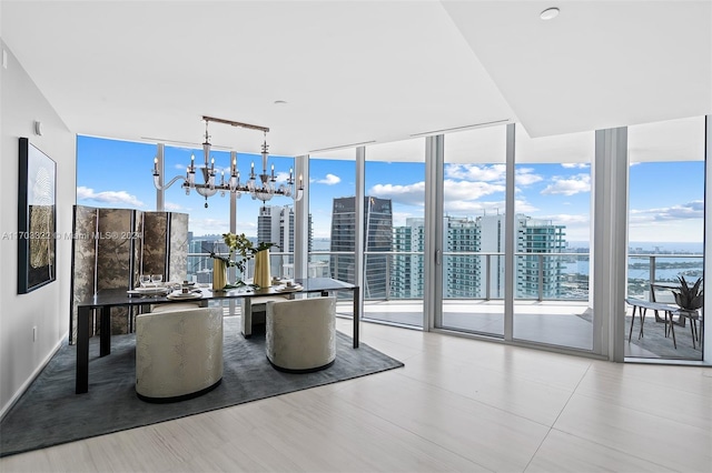 dining room featuring a wall of windows, rail lighting, a notable chandelier, and plenty of natural light