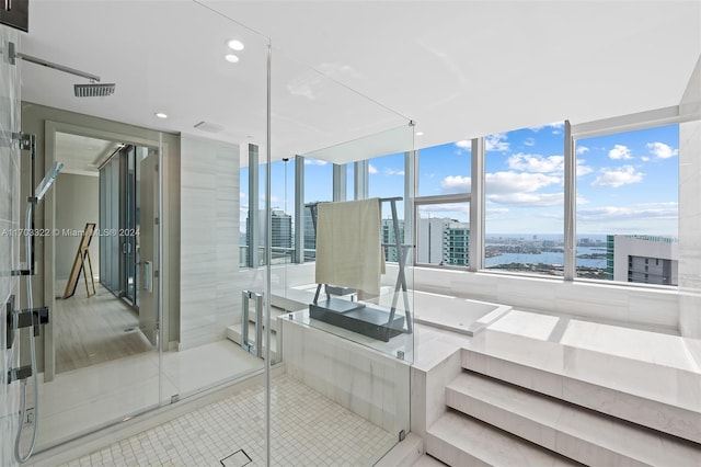 bathroom featuring floor to ceiling windows, a water view, and tile patterned flooring