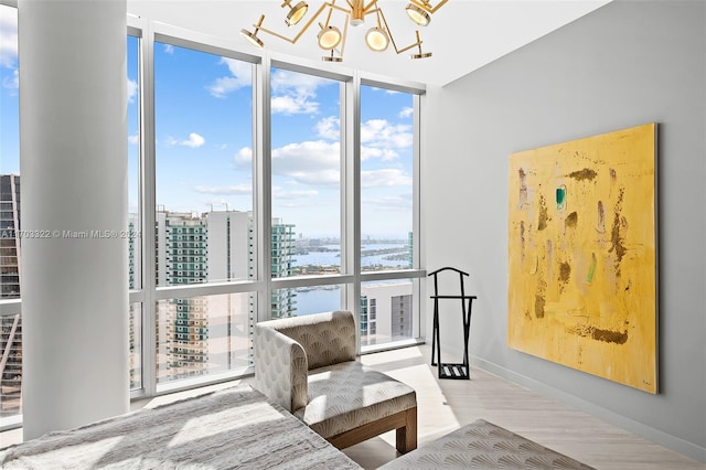 living area featuring a water view, an inviting chandelier, and floor to ceiling windows