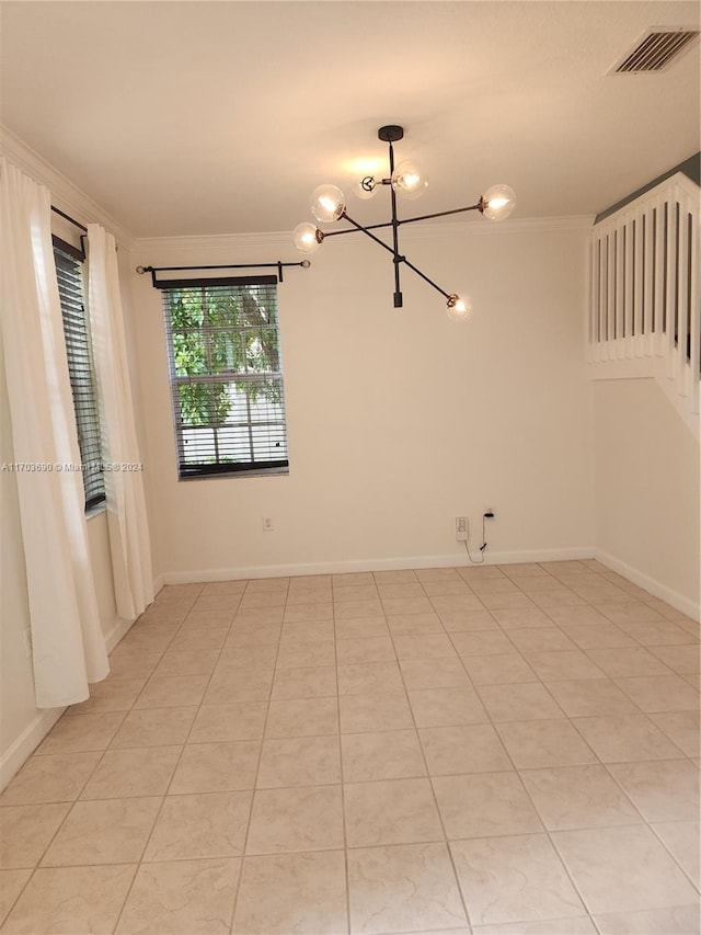 tiled spare room featuring crown molding and a chandelier