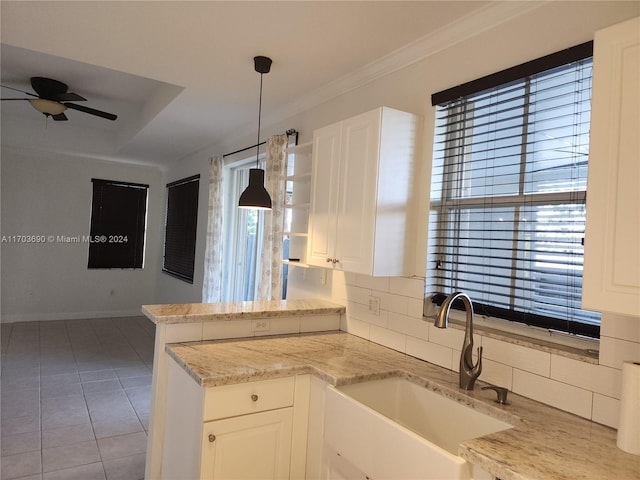 kitchen with ceiling fan, sink, hanging light fixtures, decorative backsplash, and white cabinets