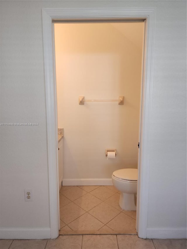 bathroom with tile patterned flooring, vanity, and toilet