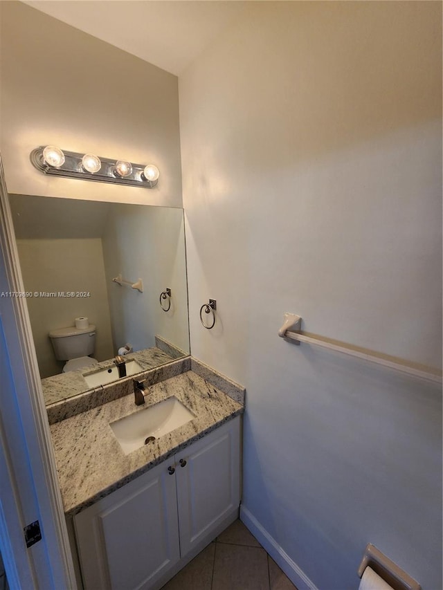 bathroom with tile patterned flooring, vanity, and toilet