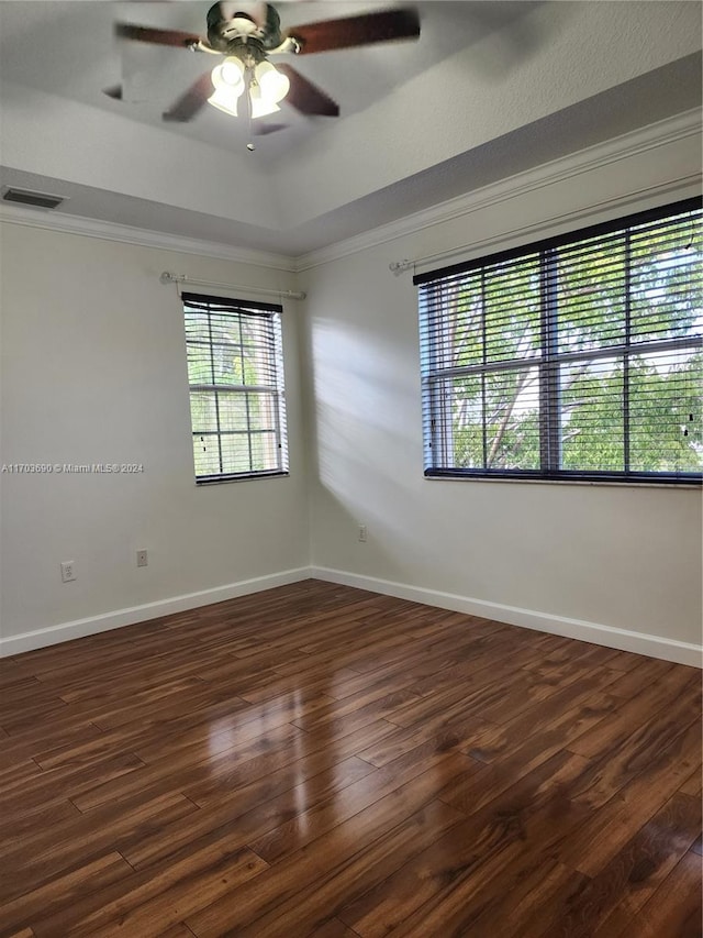 spare room with ceiling fan, crown molding, and dark wood-type flooring