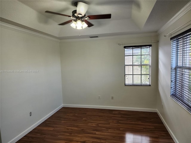 spare room featuring ceiling fan, dark hardwood / wood-style flooring, ornamental molding, and a tray ceiling