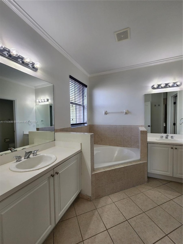 bathroom with vanity, tile patterned floors, crown molding, toilet, and tiled tub