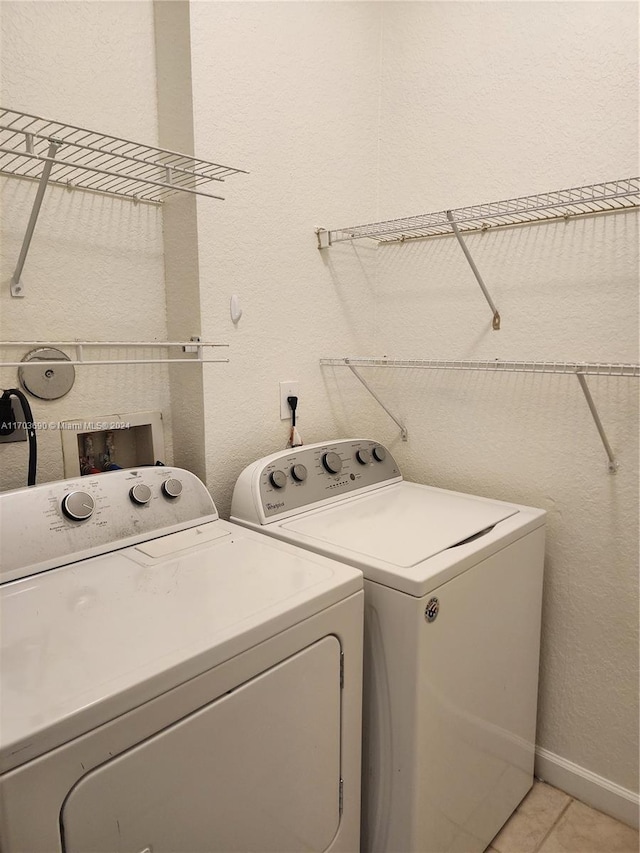 washroom with washing machine and dryer and light tile patterned flooring