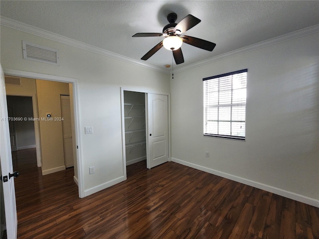 unfurnished bedroom with a textured ceiling, ceiling fan, crown molding, and dark wood-type flooring