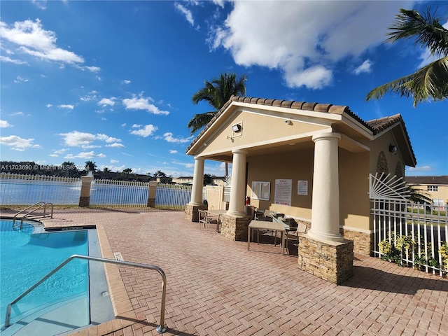 view of pool with a water view and a patio