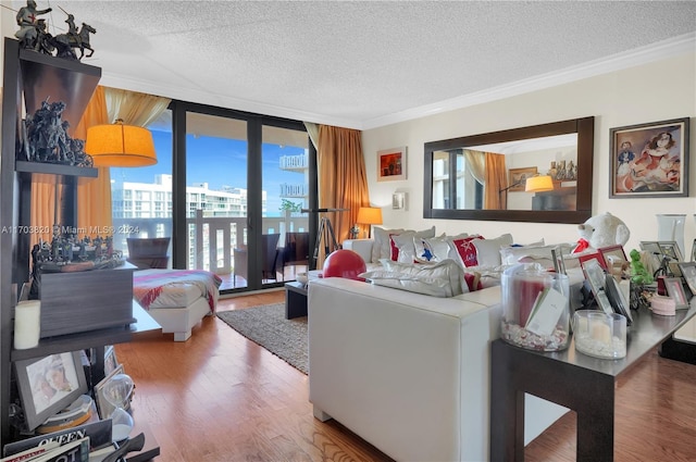 living room featuring a textured ceiling, hardwood / wood-style flooring, plenty of natural light, and crown molding