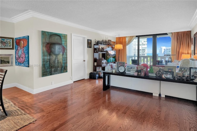 living room with hardwood / wood-style floors, a textured ceiling, and crown molding