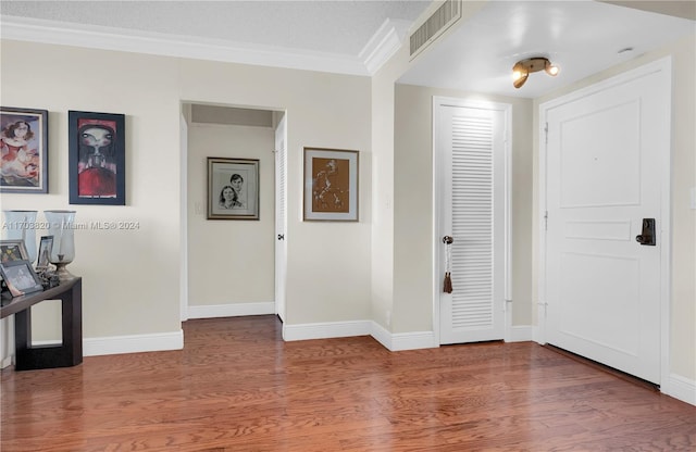 foyer entrance with hardwood / wood-style floors and ornamental molding