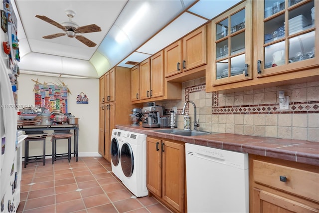 kitchen with tile counters, sink, white dishwasher, decorative backsplash, and light tile patterned floors